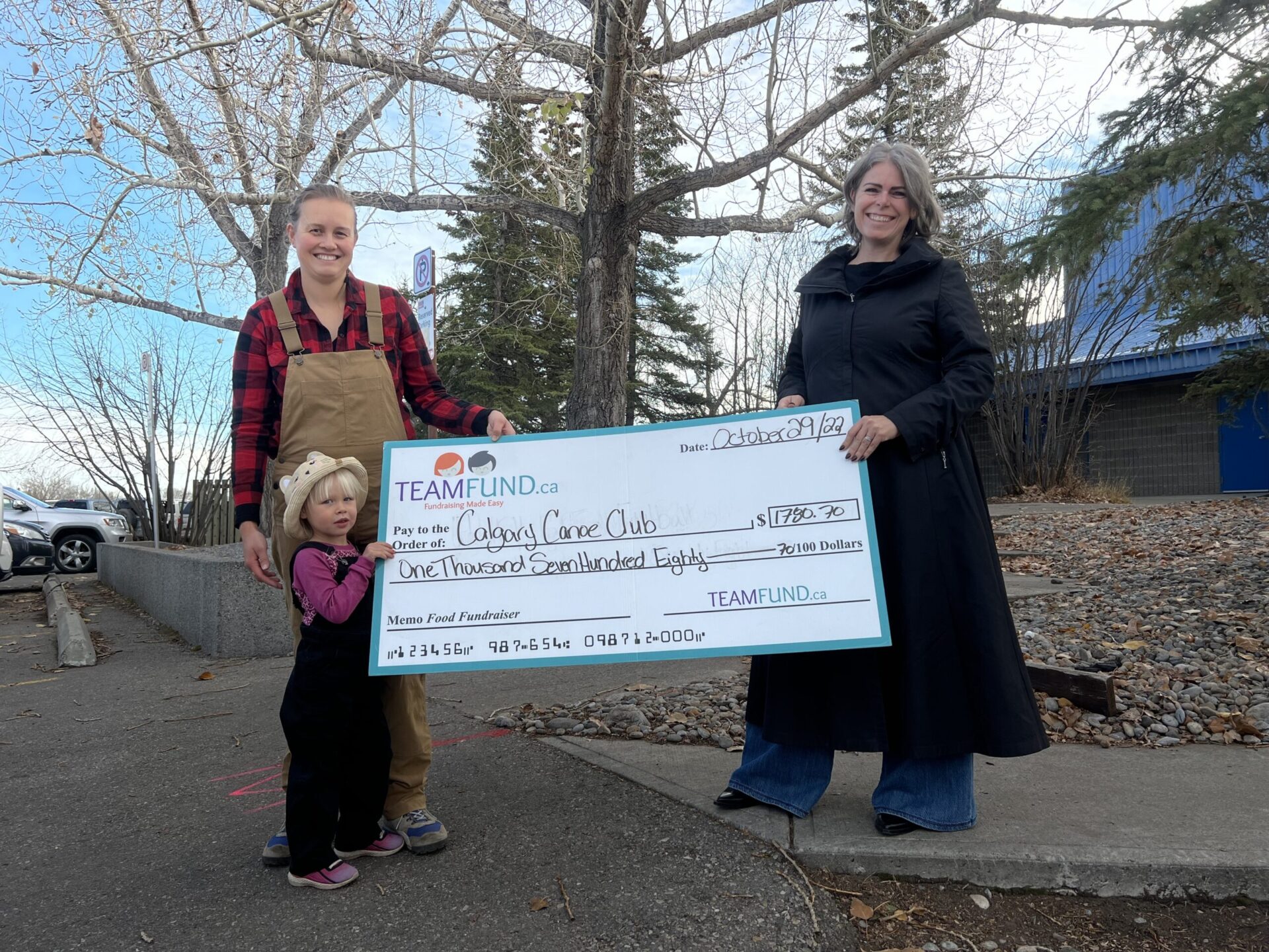 Members of the Calgary Canoe Club hold their cheque for almost $1800 in online fundraising to support their goal of attending the Canoe Kayak Championships!
