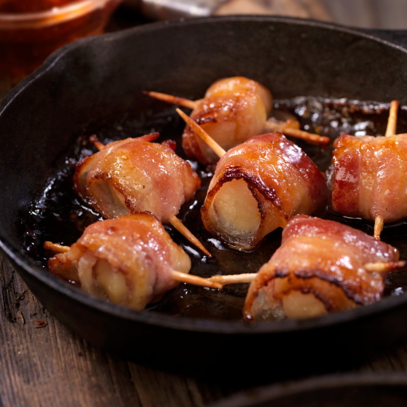 Bacon wrapped scallops in a cast iron pan