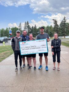 Wolverines Hockey Club, delivery in Calgary, June 2023. Holding cheque of summer fundraising where they raised almost $8000.