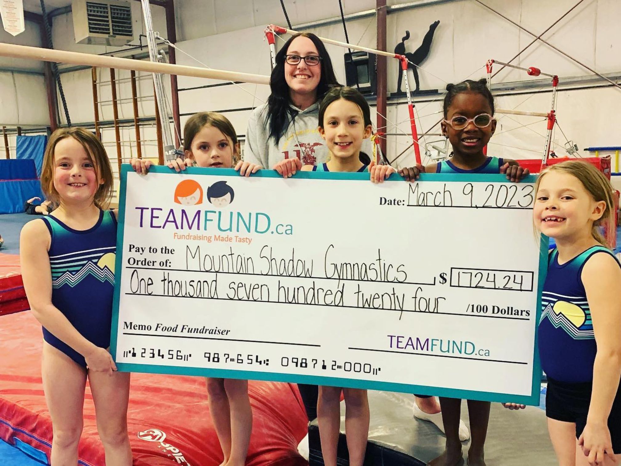 MountainShadowsGymnastics-March2023 Wolverines Hockey Club, delivery in Calgary, June 2023. Holding cheque of all time raised over $36,000.