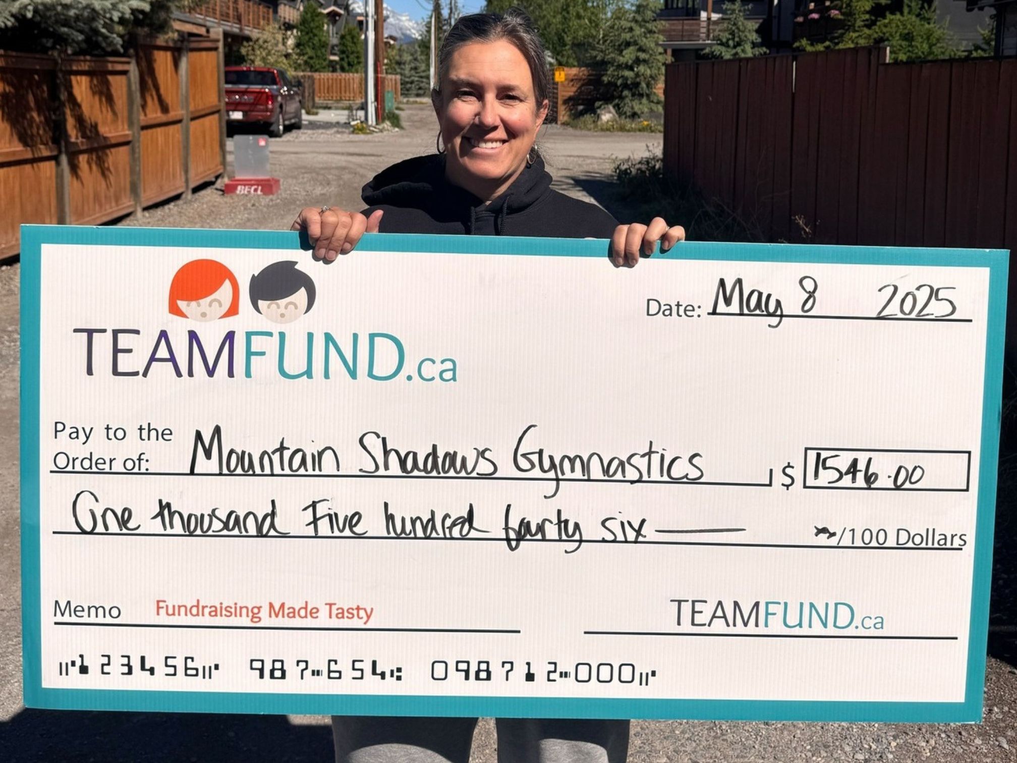 MountainShadowsGymnastics-May2025 Wolverines Hockey Club, delivery in Calgary, June 2023. Holding cheque of all time raised over $36,000.