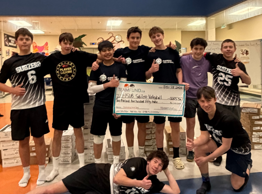 Dominique from TeamFund  Fundraising standing beside the Whitehorse sign in Whitehorse, Yukon during Subzero Volleyball Club’s first fundraiser delivery.